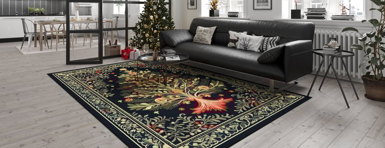 A modern living room with light wood floors, a black sofa, a decorated Christmas tree, and the Xmas Tree Washable Area Rug - MDJ005 featuring a vibrant tree design—perfect for high-traffic areas. The dining area is visible in the background.
