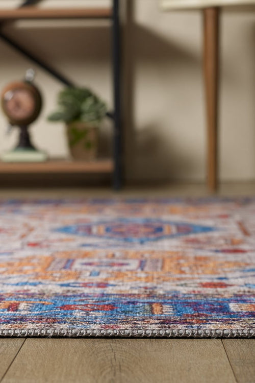 Load image 1 in gallery view. A close-up of the Yonder Blue Cream Washable Rug - LCC3045 (Custom Size) showcases its vibrant multicolor patterns on a wooden floor—ideal as a stylish, easy-to-clean rug for busy spaces.