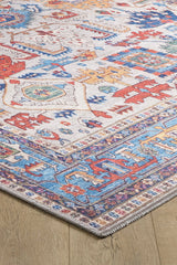 A close-up of the Yonder Blue Cream Washable Rug - LCC3045 (Custom Size) displaying red, blue, yellow, and orange geometric and floral patterns on a light background—ideal for any wooden floor.