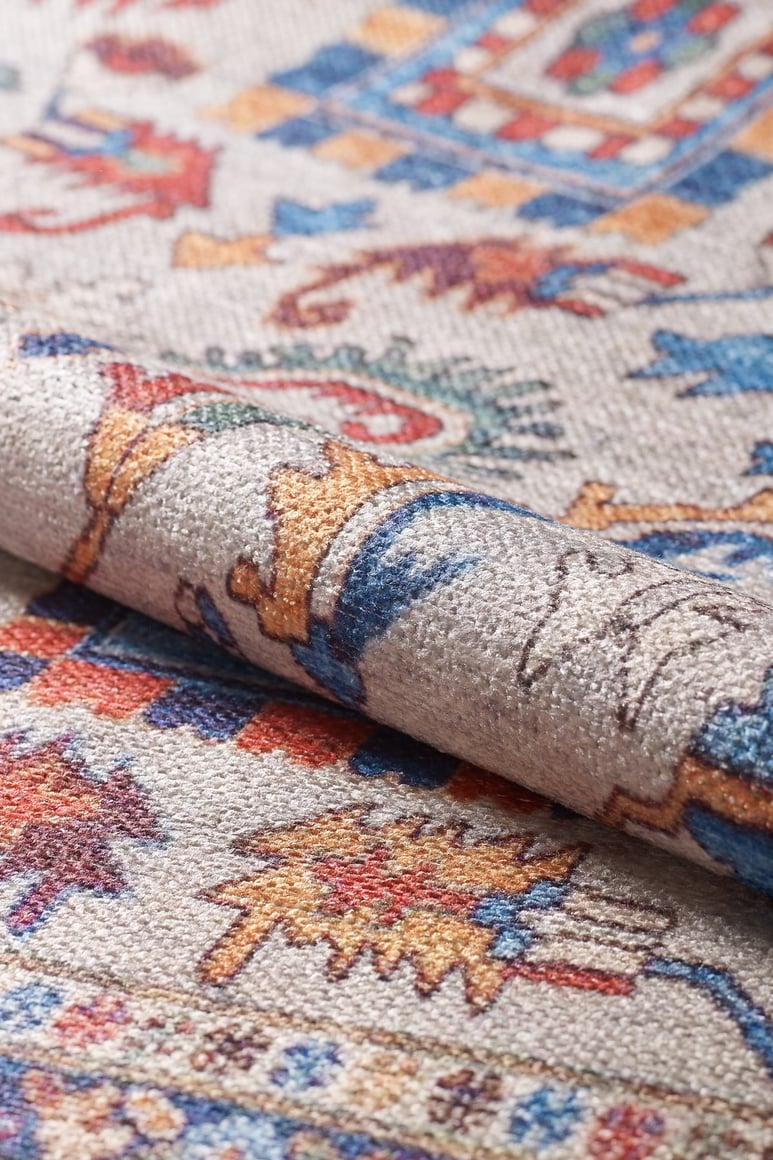 A close-up of the Yonder Blue Cream Washable Rug - LCC3045 (Custom Size) shows its vibrant geometric and floral patterns in red, blue, yellow, and beige—an ideal washable rug for high-traffic areas.