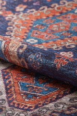 A close-up of the Zephyro Kilim-Design Washable Rug - LCC3008 (Custom Size), showcasing its intricate blue, orange, red, and white geometric patterns. Ideal for high-traffic spaces with a visible fabric texture and detailed design.