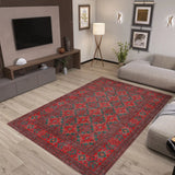 Living room with a red patterned rug, gray sofa, and TV stand.