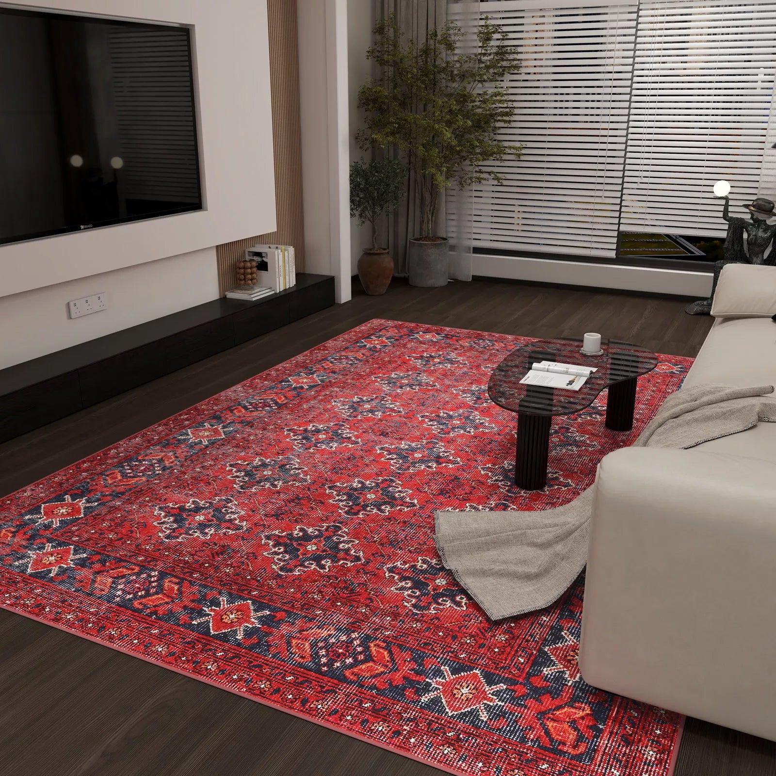 Living room with a red patterned rug, beige sofa, and coffee table.
