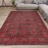 Red and green patterned rug on a wooden floor in a living room setting.