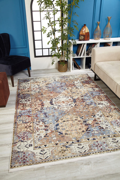 Load image 1 in gallery view. The Native Nature's Washable Rug - JR1666 (Custom Size) with vibrant geometric and floral patterns adds style to a modern living room with a beige sofa, black chair, tall plant, and blue paneled walls—ideal for high-traffic areas.