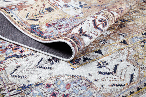 Load image 1 in gallery view. A close-up of Native Nature's Washable Rug (JR1666, Custom Size), with one corner folded to reveal the underside. The rug showcases intricate earthy designs accented by blue, cream, and red—perfect for high-traffic spaces.