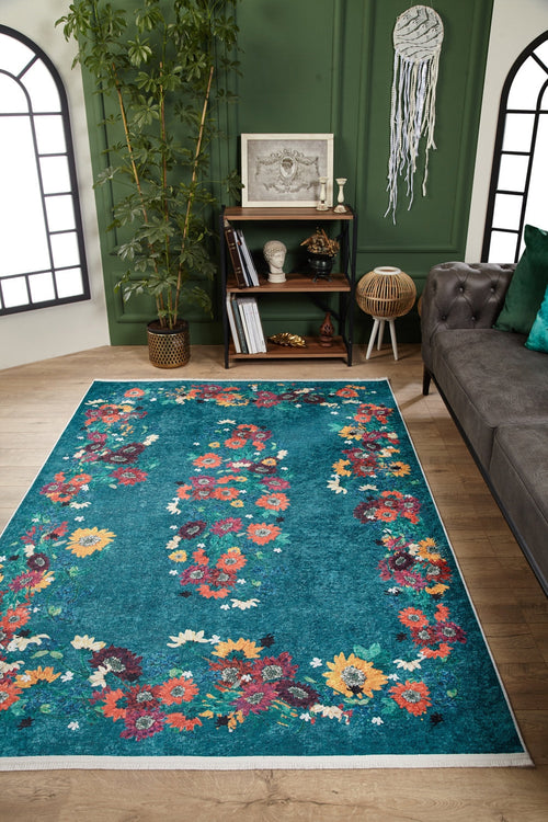 Load image 1 in gallery view. A living room features the Nature's Tapestry - Washable Rug - JR1674 (Custom Size) in teal floral, green paneled walls, gray sofa, bamboo plant, and styled bookshelf. Macramé accents and arched windows create a cozy, eclectic vibe for busy spaces.