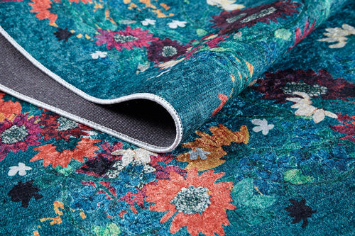 Load image 1 in gallery view. Close-up of Nature's Tapestry - Washable Rug - JR1674 (Custom Size): a vibrant, multi-colored floral rug with a teal background. The folded corner shows its textured, non-slip gray backing and sturdy edge stitching—ideal for high-traffic areas.