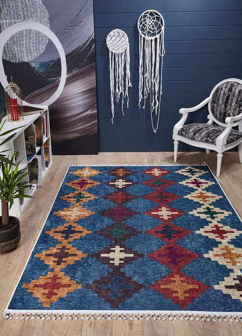 Load image 1 in gallery view. A room with a Nomad's Mirage - Washable Rug - JR5032 (Custom Size) on wooden flooring, a white armchair with a patterned cushion, wall art and dreamcatchers on a dark blue wall, plant, and white bookshelf—ideal for high-traffic areas.