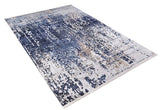 The Abstract Atmosphere - Washable Rug - JR834 is a rectangular flat weave with a modern distressed abstract pattern in blue, beige, and white on a light background.