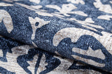 A close-up of the Antique Flourish - Washable Rug - JR1591 shows its textured surface with a bold, abstract floral and leaf pattern in dark blue and beige—perfect as a stylish, washable rug for high-traffic areas.