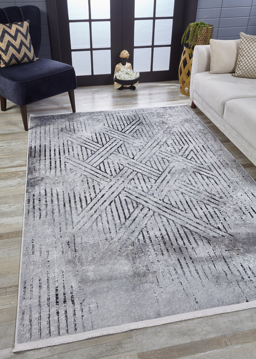Load image 1 in gallery view. A modern living room with the Art Deco Empress - Washable Rug - JR1867 in gray-anthracite, a navy chair with a zigzag pillow, white sofa, decorative vase, and sunlight through a glass door—ideal for high-traffic areas.