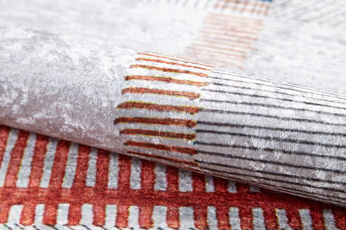Bild 1 in Galerieansicht laden. A close-up of the Bohemian Nightscape - Washable Rug (JR1701) shows its soft, textured fabric and modern geometric pattern in red, orange, and beige on a white-gray background—durable and stylish for high-traffic areas.
