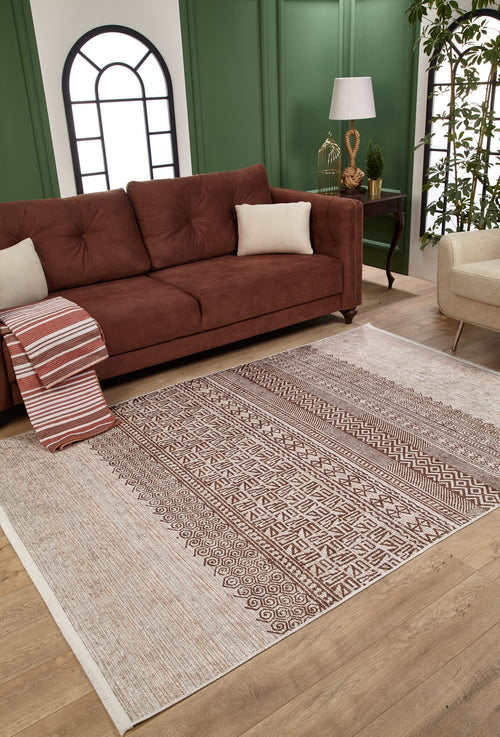 Load image 1 in gallery view. A living room featuring a brown sofa, white cushion, striped throw blanket, Bohemian Treasure - Washable Rug - JR1586—ideal for high-traffic areas—a lamp on a side table, green paneled walls with arched windows, beige chair, and plant.