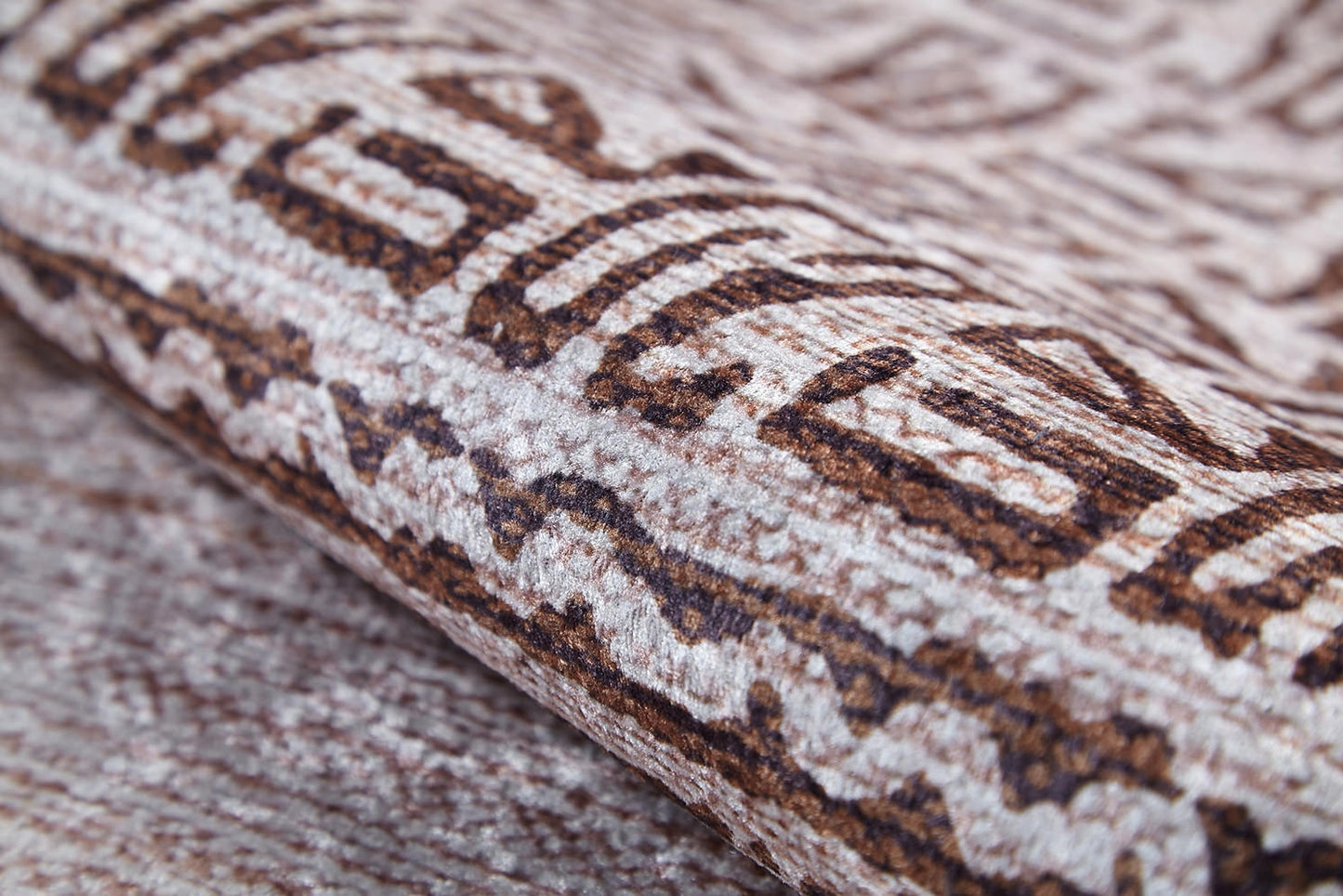 A close-up of the Bohemian Treasure - Washable Rug (JR1586) highlights its geometric brown and beige pattern, fine stitching, and soft fibers—an ideal choice for allergy-sensitive homes and busy spaces.