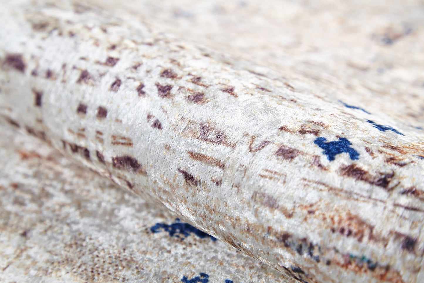 A close-up of the Boho Babe - Washable Rug - JR1664 (Outlet) US shows its light, textured fabric in cream and beige with abstract brown and blue accents. Soft and slightly reflective, it's perfect for a flat weave or washable rug design.