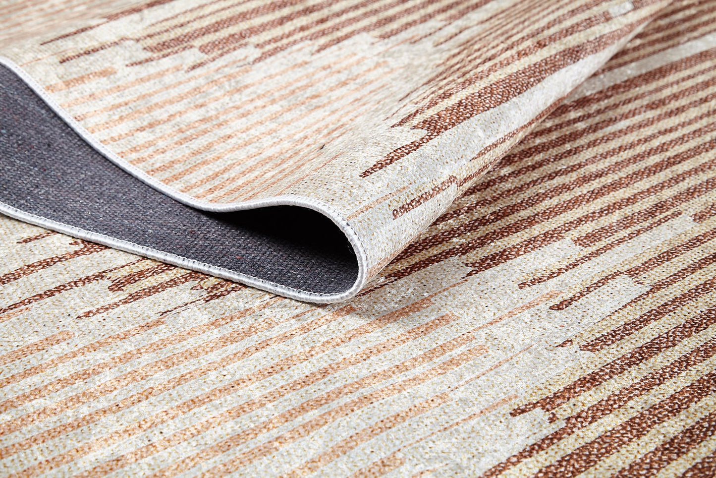 A close-up of the Boho Paradise - Washable Rug - JR2004 shows cream and beige flat weave with abstract horizontal lines and one folded corner exposing its dark gray underside.