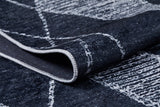 A close-up of the Byzantine Beauty - Washable Rug - JR1037, featuring a folded dark blue surface with a white geometric pattern and visible stitched edging. The texture and design details are clear, perfect for high-traffic areas.