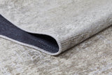 A close-up of the Cinnamon Swirl - Washable Rug - JR425 in cream and beige, featuring a textured surface, folded corner revealing the dark underside and stitched edging—ideal for high-traffic areas.
