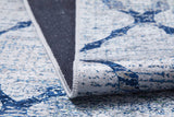A close-up of the Classic Trellis - Washable Rug - JR710 features blue geometric patterns, with a corner folded to reveal its textured, dark non-slip backing.