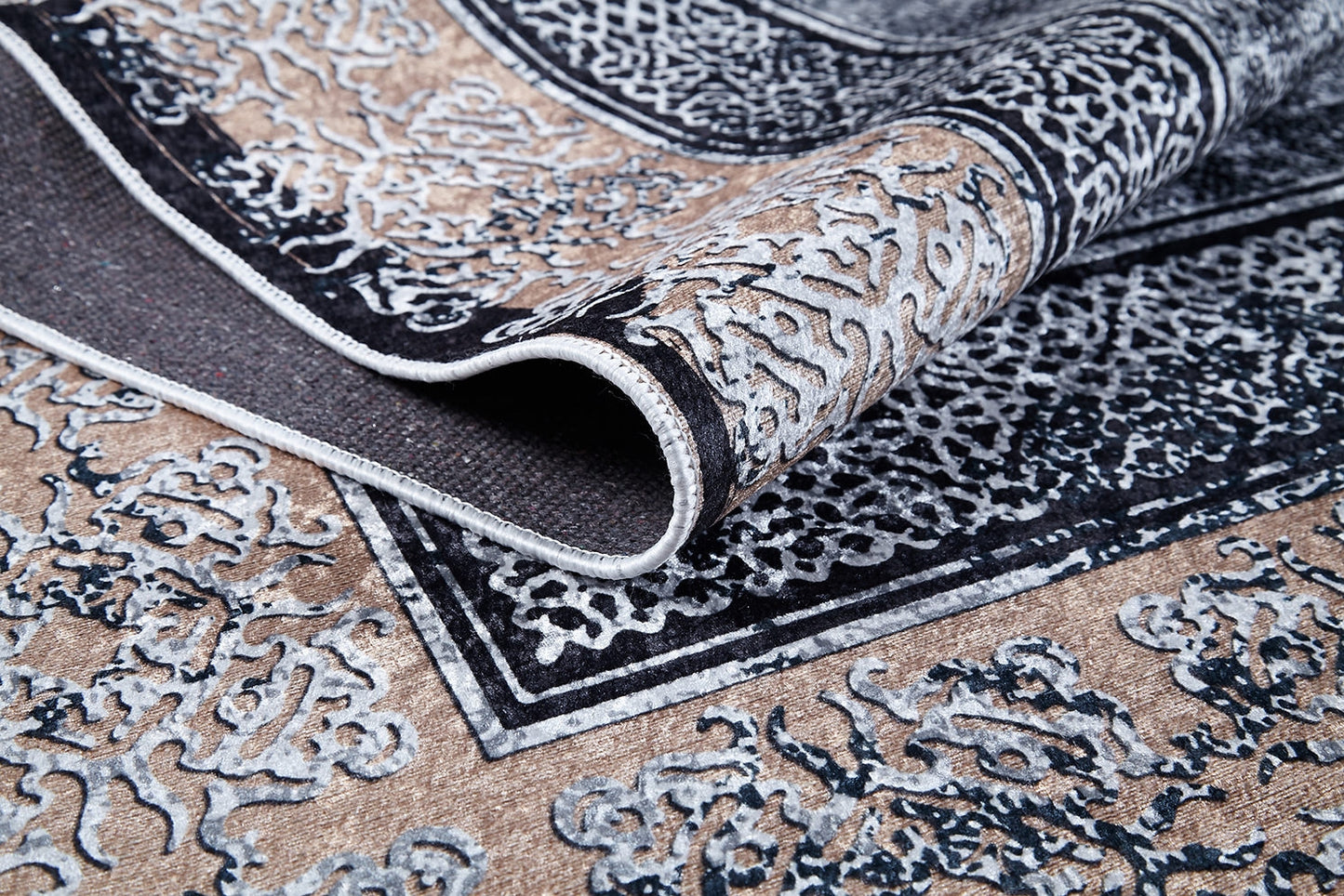 A close-up of the Contemporary Borderline - Washable Rug - JR1798 reveals its ornate beige and black flat weave, a folded corner highlighting intricate textures—an allergy-friendly, stylish addition perfect for any space.