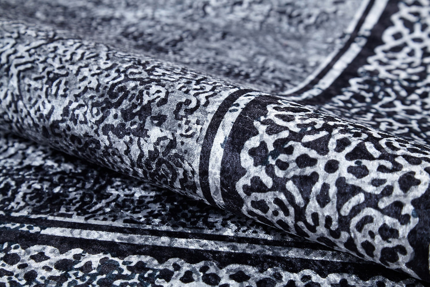 A close-up of the Contemporary Borderline - Washable Rug - JR1798 shows its intricate black and white abstract pattern with textured shapes and bold borders—an allergy-friendly, modern rug that brings elegance to any space.