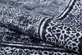 A close-up of the Contemporary Borderline - Washable Rug - JR1798 shows its intricate black and white abstract pattern with textured shapes and bold borders—an allergy-friendly, modern rug that brings elegance to any space.