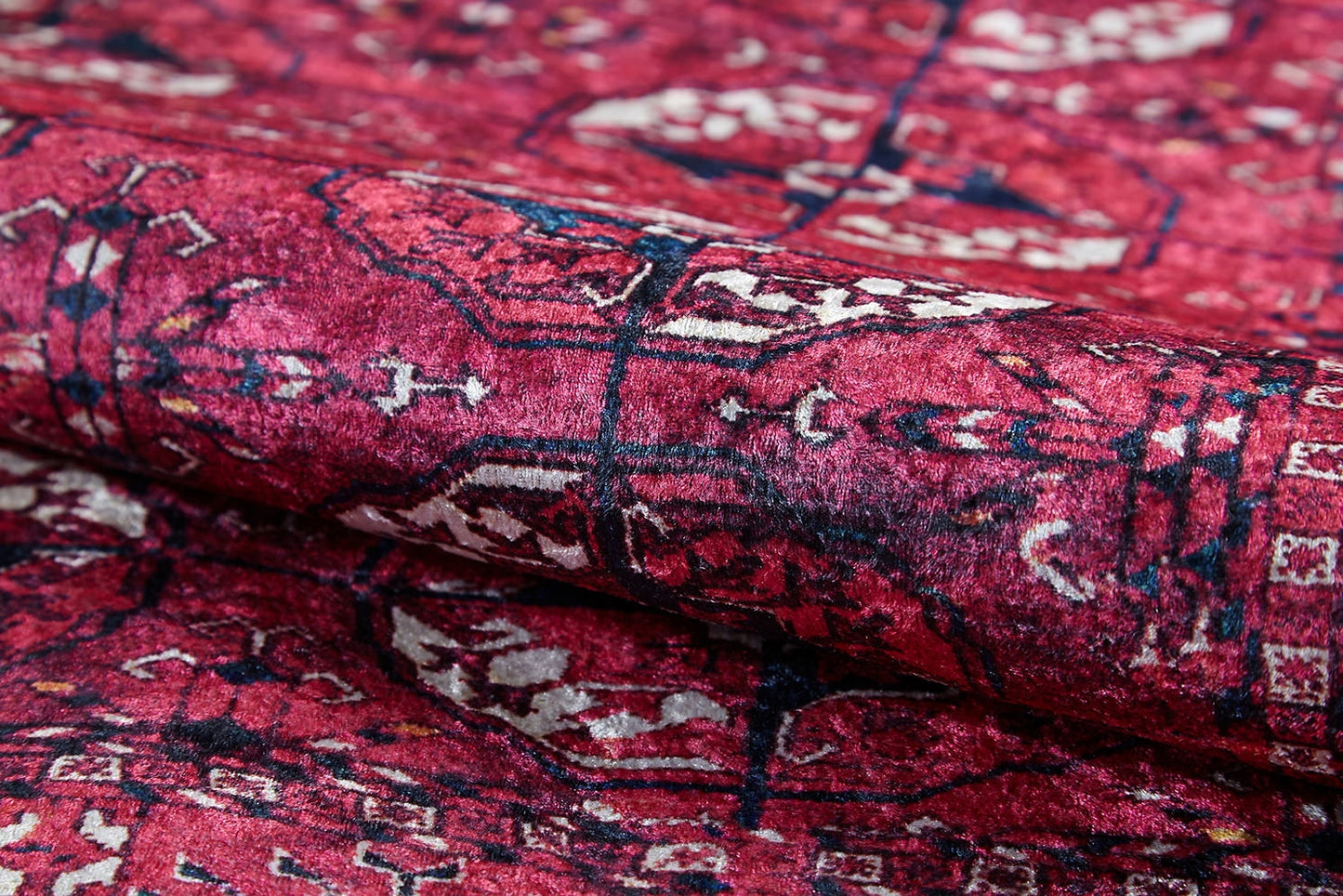 Close-up of the Desert Dreamscape - Washable Rug - JR1940 in soft pink, featuring intricate white, red, and black geometric and floral designs; partially folded to highlight its detailed texture and washable quality.