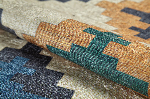 Load image 1 in gallery view. A close-up of the Desert Mirage - Washable Rug - JR5033 highlights its green, gold, navy blue, and beige geometric pattern and flat weave texture.