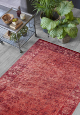 The Dynasty Dream - Washable Rug - JR160 with a red oriental pattern lies on a light wood floor beside a metal table with décor and potted plants, adding warmth and style to this modern living space.