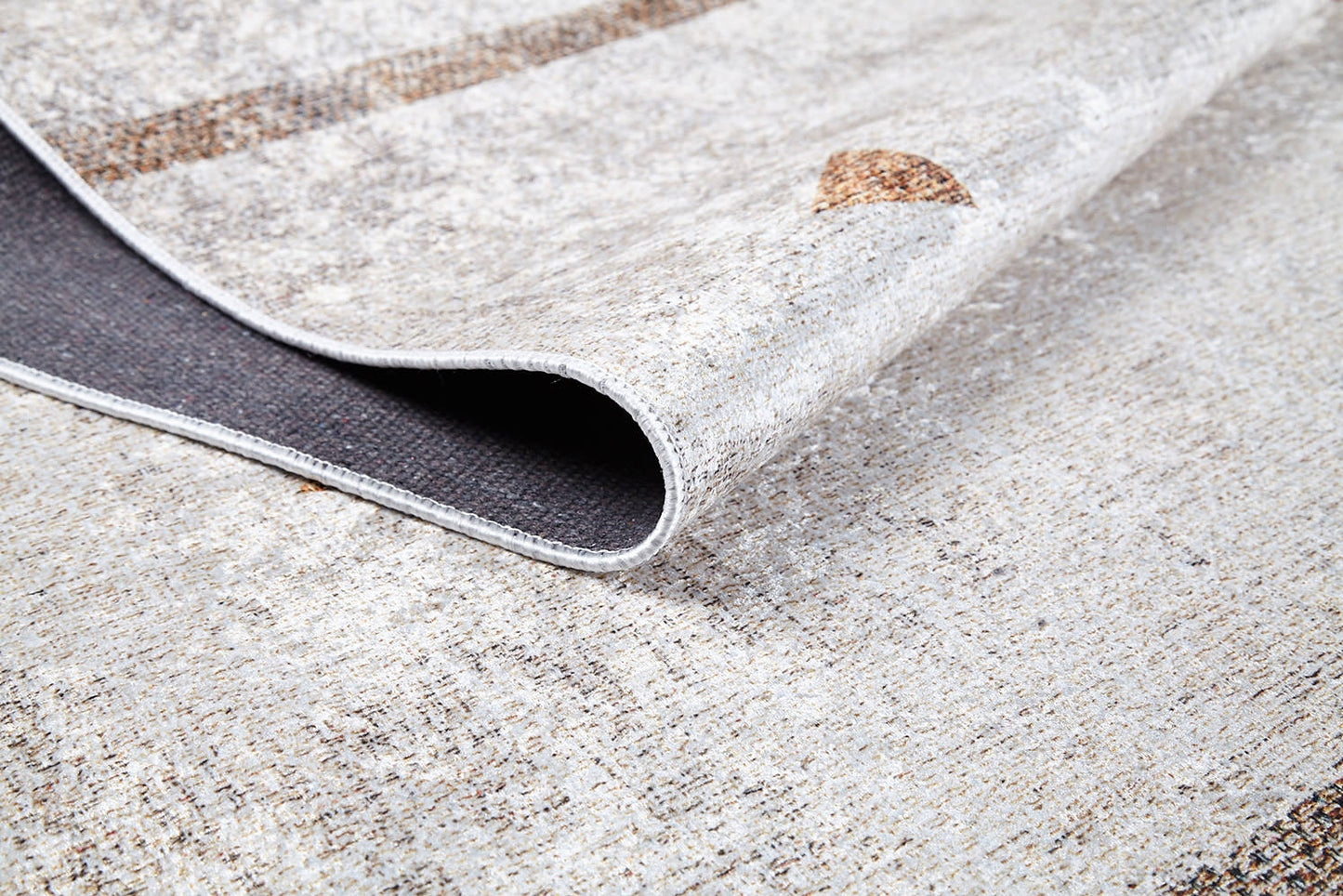 A close-up of the Ebony Ivory - Washable Rug - JR1994 highlights its subtle pattern, light color, and dark underside. The visible texture and weave make it perfect for allergy-sensitive or high-traffic areas.