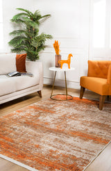A modern living room with a beige sofa, orange chair, round white table displaying a vase of orange flowers and a decorative horse. The floor features the Fluffy Brushed - Washable Rug - JR584 in orange, with a tall plant in the corner.
