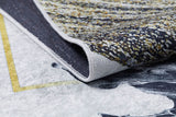Close-up of Funky Floral Frenzy - Machine-Washable Rug JR1376, showcasing a folded corner that reveals its speckled yellow, black, and white textured top and grey underside—perfect for high-traffic areas—with a yellow border on a light-colored floor.
