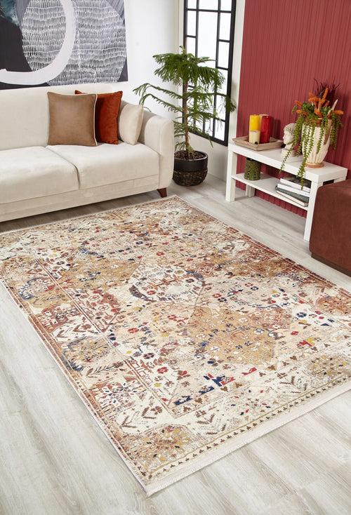 Load image 1 in gallery view. A cozy living room with a beige sofa, decorative cushions, potted plant, and the Global Getaway - Washable Rug - JR1667 featuring tan, red, and blue accents—perfect for high-traffic areas. A white table with plants stands by a bold red accent wall.