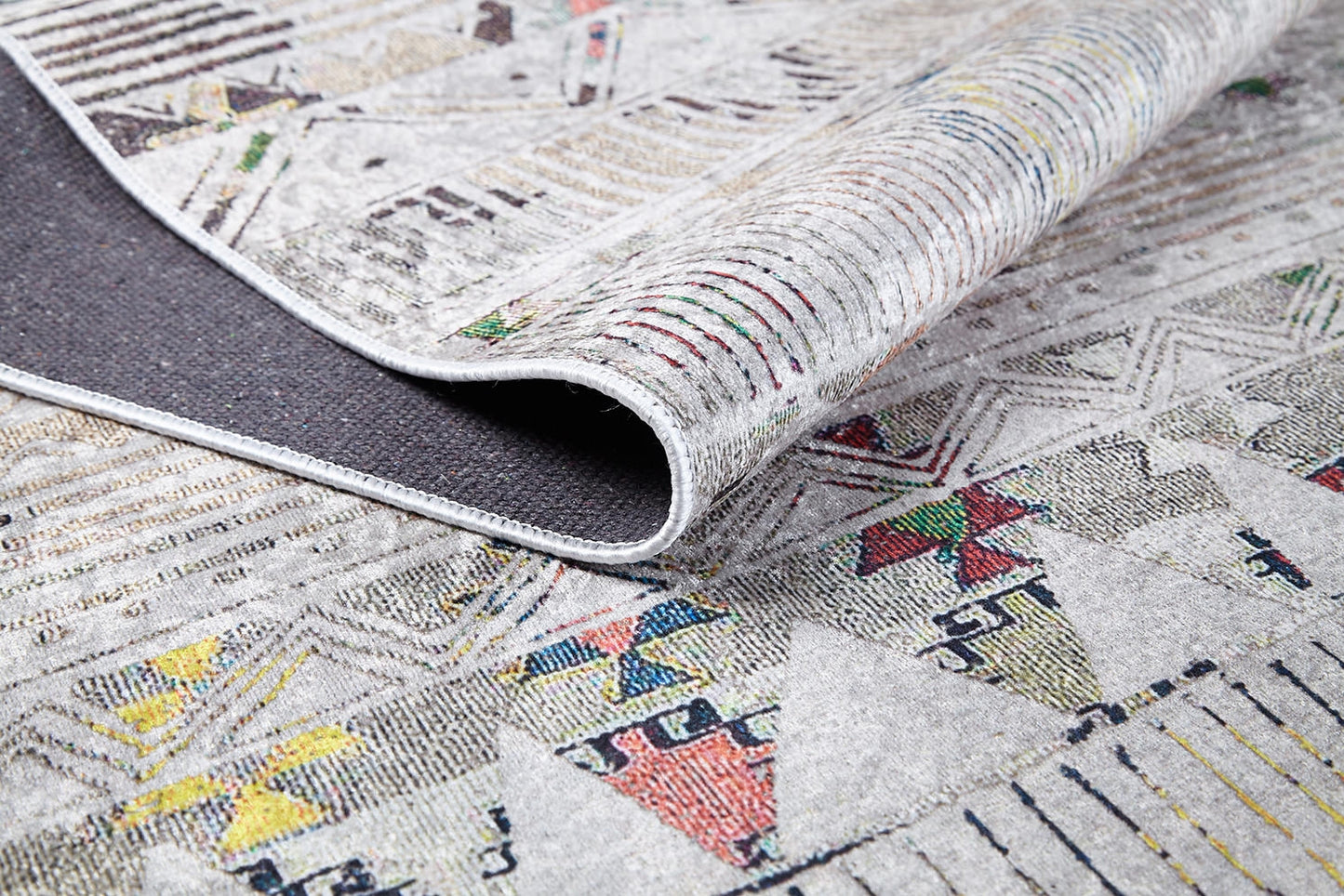 The Gypsy Glam - Washable Rug - JR1716 features colorful geometric patterns and detailed edge stitching, with its dark, textured underside partially visible—ideal for high-traffic areas and easy to clean.