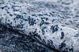 The Imperial Lace - Washable Rug - JR1607 showcases a marbled blue, gray, and black design with a soft, velvety feel. Its subtle color variations and durable, washable fabric make it ideal for high-traffic areas.