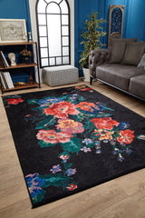 A modern living room with a gray sofa, Meadow Dream - Washable Rug - JR2001 featuring colorful flowers—perfect for high-traffic areas—tall geometric window, bookshelf, potted plant, patterned ottoman, and blue walls.