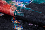 A close-up of the Meadow Dream - Washable Rug - JR2001 shows its dark, black background with intricate red, green, blue, and beige patterns. The woven texture is visible and the rug is washable—ideal for high-traffic areas.