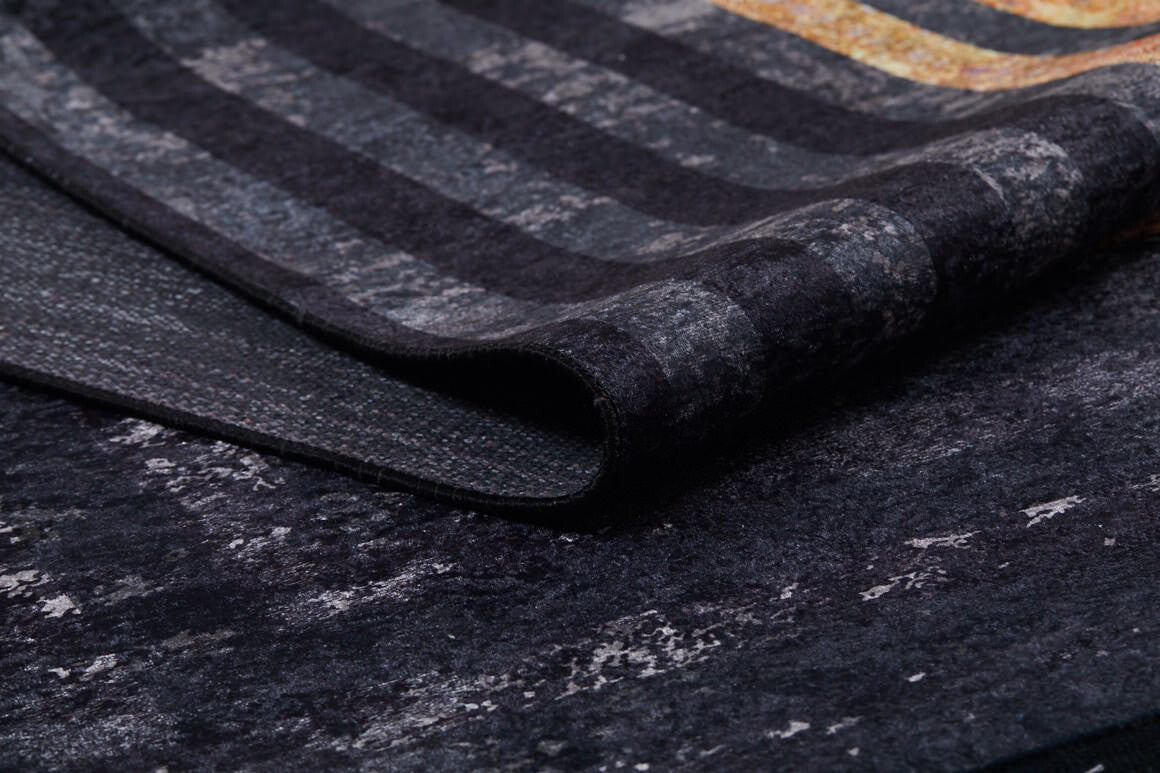 A close-up of the Minimalist and Clean - Washable Rug - JR1407 shows black and gray stripes with a subtle pattern and hints of gold. This textured, washable rug is perfect for high-traffic areas in your home.