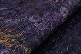 A close-up of the Minimalist and Elegant - Washable Rug - JR1298 shows a dark, textured surface with purple swirling patterns and gold accents, offering an ornate design that's decorative and ideal for high-traffic areas.