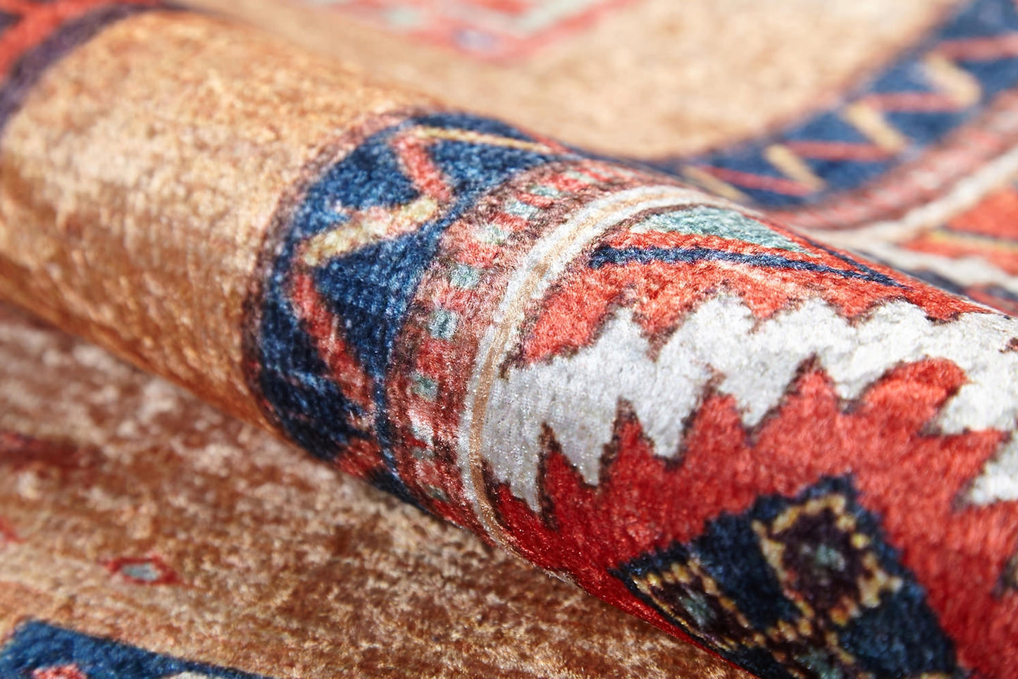 A close-up of the Navajo Nights - Washable Rug (JR1758) shows detailed geometric patterns in red, blue, white, and beige. Its textured surface and curved fold offer vibrant style that’s perfect for high-traffic areas.