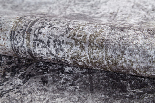 Load image 1 in gallery view. A close-up of the Noble Insignia - Washable Rug - JR1830 rolled up, showcasing its soft texture, grey tones, and subtle faded pattern. Its slightly distressed design makes it perfect for high-traffic areas.