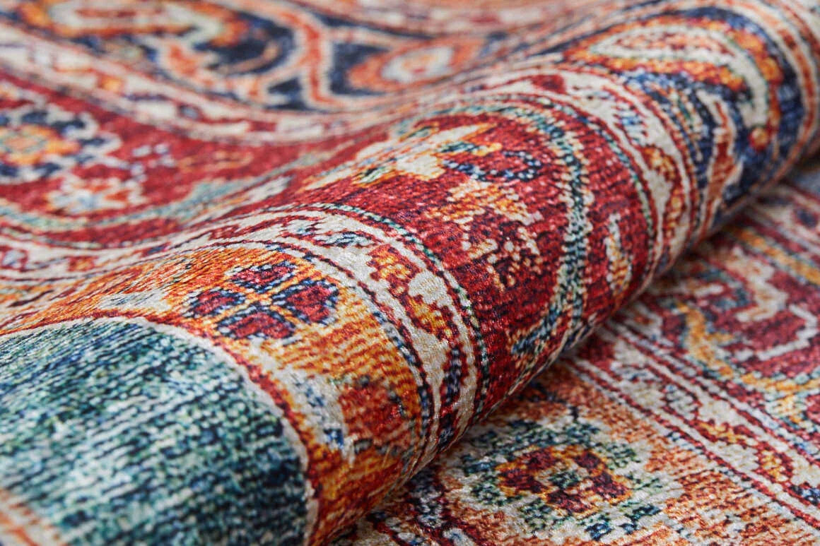 A close-up of the Old-World Elegance - Washable Rug - JR38 (Outlet) US showcases its colorful, intricate red, orange, blue, and cream patterns with detailed weaving and texture as the washable rug is partially rolled.
