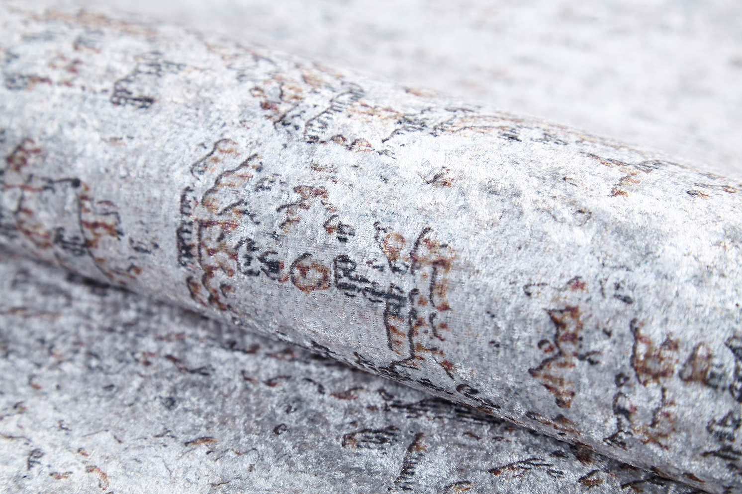 A close-up of the Opulent Tapestry - Washable Rug - JR1775 in light gray, featuring a soft, plush texture and a subtle abstract pattern in brown and black—ideal for high-traffic areas and easy to keep clean.