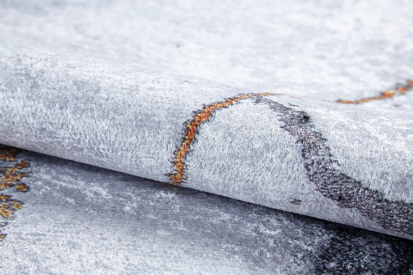 A close-up of the Opulent Veins - Machine-Washable Rug JR1593, featuring a light gray textured surface with orange and dark gray abstract patterns—soft, slightly shiny, and ideal for high-traffic areas.
