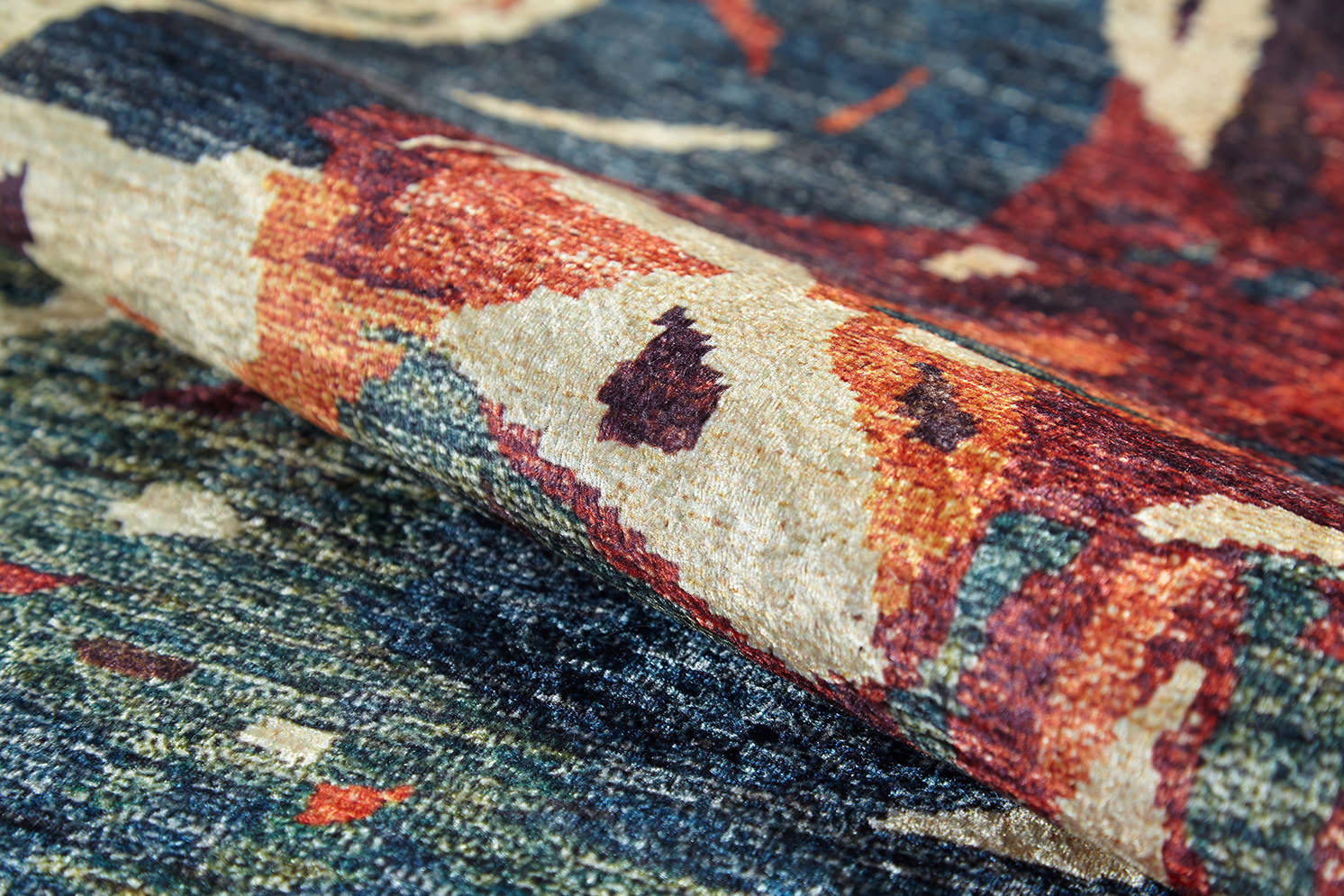 A close-up of the Psychedelic Splash - Machine-Washable Rug (JR5096) shows its plush, woven texture and colorful abstract patterns in blue, red, orange, and beige—ideal for allergy-sensitive or high-traffic areas.