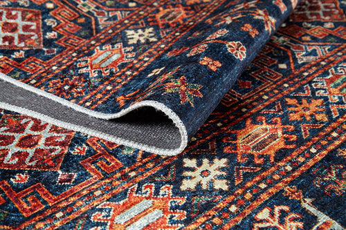 Load image 1 in gallery view. A close-up of the Sahara Sunrise - Washable Rug - JR5091, featuring blue, orange, red, and cream geometric and floral designs. Partially folded to show texture and underside; ideal for high-traffic areas while adding vibrant style.