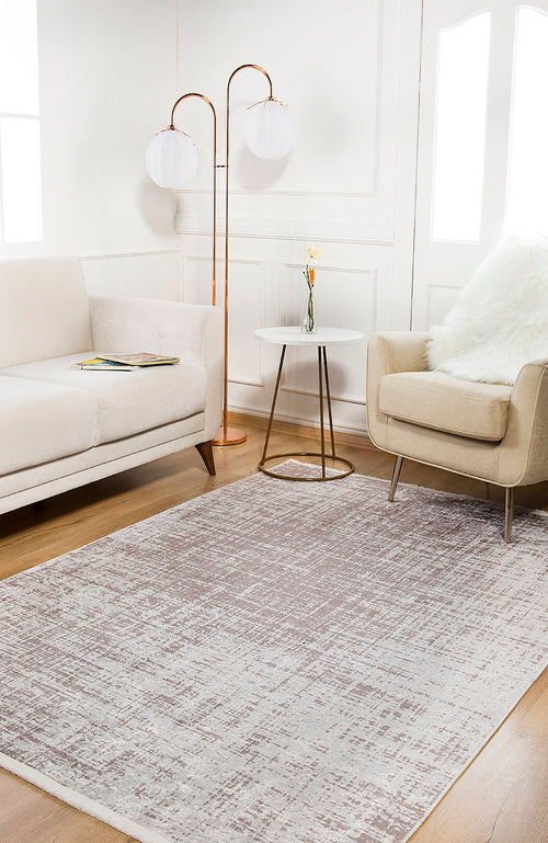 Load image 1 in gallery view. A modern living room features a beige sofa, tan armchair with a white throw, round side table with a small vase, globe floor lamp, and the Sea Spray - Washable Rug - JR847 in cream and beige on wooden flooring.