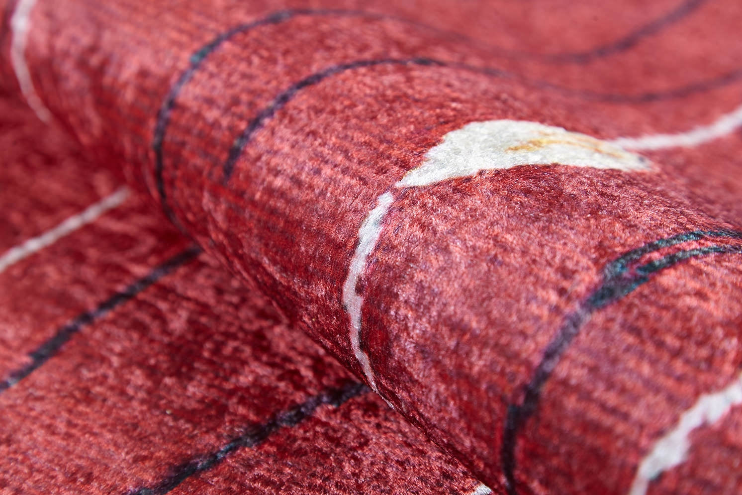 Close-up of the Secret Garden - Washable Rug - JR1656: red with textured fibers, curved black lines, and a white accent—its soft, durable design makes it ideal for high-traffic areas and easy to clean.