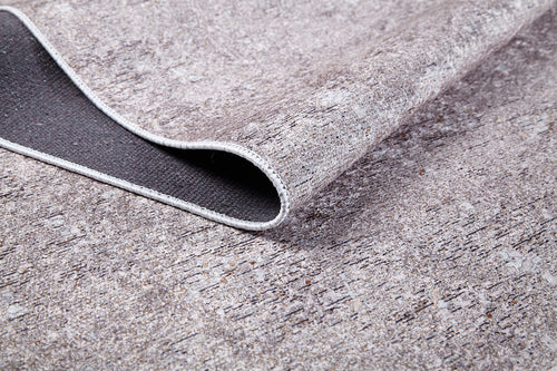 Load image 1 in gallery view. A close-up of the Slate Charm - Washable Rug (JR1740) shows its cream and beige, stone-textured pattern with dark backing and stitched edge—durable, washable, and ideal for high-traffic areas.